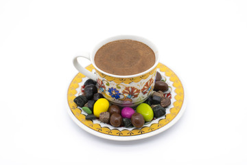  Turkish coffee with chocolate around it on white. Turkish cup of black coffee. colored chocolates