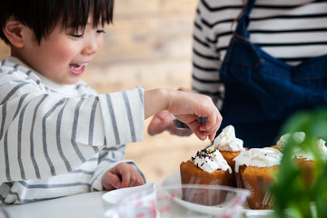 ケーキにチョコのトッピングをする男の子