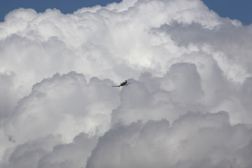 Vintage plane flying towards clouds above the Atherton Tableland in Tropical North Queensland, Australia