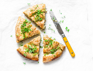 Greek spinach fresh ricotta puff pastry pie on a light background, top view. Spanakopita pie