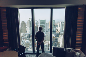 Man Silhouetted in City Window