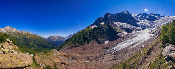Fototapeta na wymiar Huge mountain glacier in the surroundings of Dombai. Caucasus Mountains summer, clear day.