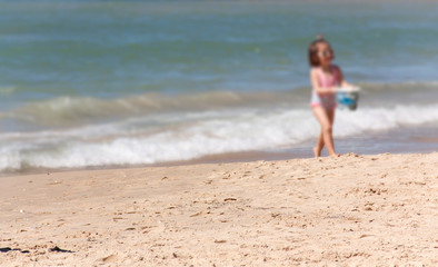 Fototapeta na wymiar little girl at the water's edge as background