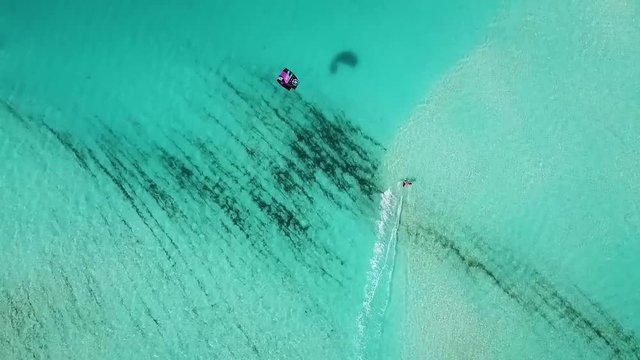 A Kite boarder glides across the turquoise waters of the Turks & Caicos Islands, in a display of warm summer water sports.