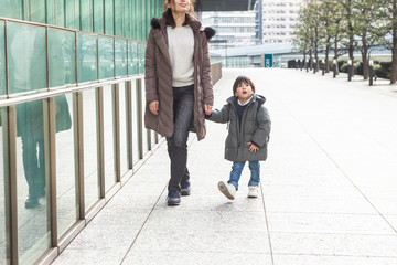 母と息子が仲良く手を繋いで歩いている