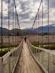 Landscape near Vicuña in Chile with a girl crossing a suspension bridge