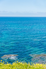 Fototapeta na wymiar Clear Blue Sky Over the Turquoise Waters of the Southern Mediterranean Sea on the Italian Coast