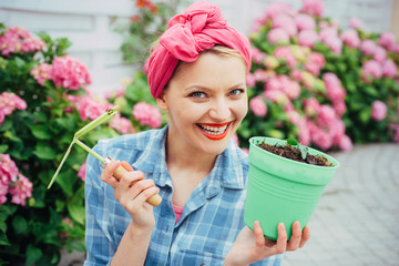 happy woman gardener with flowers. woman care of flowers in garden. Flower care and watering. soils...