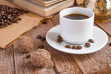 fresh coffe breved in cezve (traditional turkish coffee pot) morning beverage in white cup next to chocolate balls