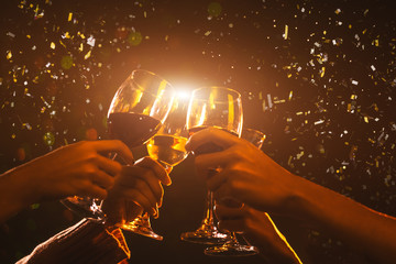 Clink Glasses at night party celebration friends group golden tone, Hands holding wine for event...
