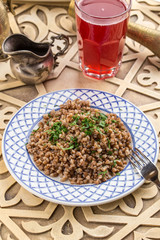 cooked buckwheat on white plate with berry juice on oriental table