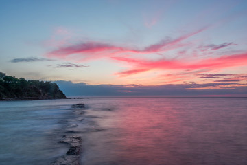 Fototapeta na wymiar Long Exposure of a Sunset on the Southern Mediterranean Sea in Italy with Ancient Roman Wall