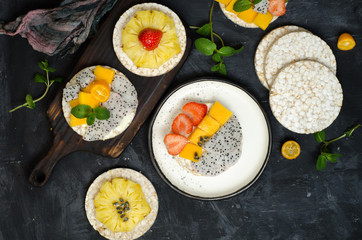 Multigrain rice cakes sandwich with berries, fruit and cream cheese for healthy breakfast.
