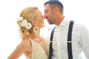 Wedding photo shoot of the newlyweds wedding couple in a beautiful hotel posing near window