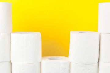 Toilet paper stacks  on bright yellow background