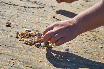 Girl lays out a drawing in the sand.