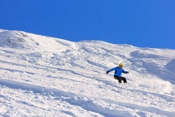Naklejka na ściany i meble Snowboard rider on a steep slope