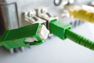 green connector optical patch cord on the background of the optical receiver to broadcast the TV