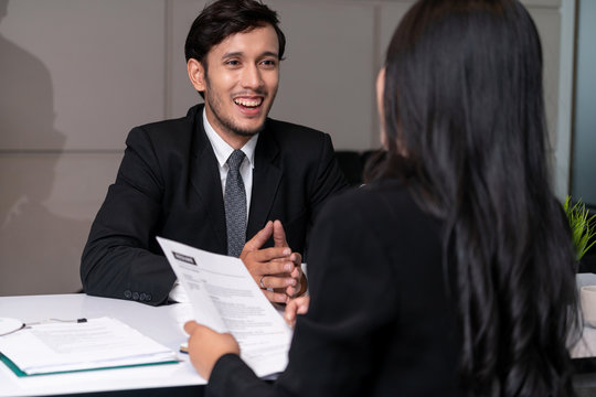Human resource manager interviewing the male employment candidate in the office room. Happy job interview. Job application, recruitment and Asian labor hiring concept.