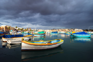 Fototapeta na wymiar Gloomy sky over fisher village Marsaxlokk, Malta