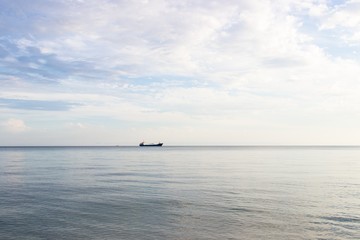Obraz premium Tranquil seascape with ship at background