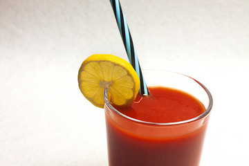 ZUMO NATURAL DE TOMATE CON RODAJA DE LIMON SOBRE FONDO BLANCO
