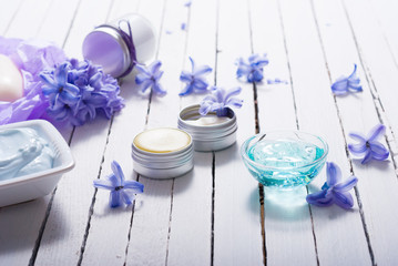 skin care product samples and purple hyacinth flowers on white wooden