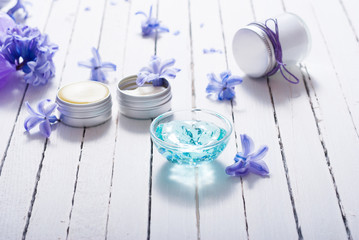 skin care product samples and purple hyacinth flowers on white wooden
