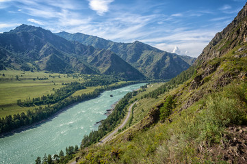 Naklejka na ściany i meble Katun river in Altai flows between the mountains covered with greenery
