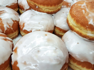 Close-up on a group of fresh donuts with icing for sale in a grocery store or bakery