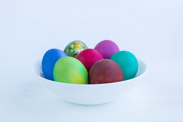 Fototapeta na wymiar White plate of Easter versicolored boiled eggs decoration isolated