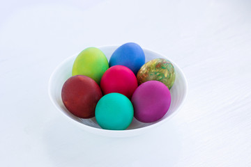 White plate of Easter versicolored boiled eggs decoration
