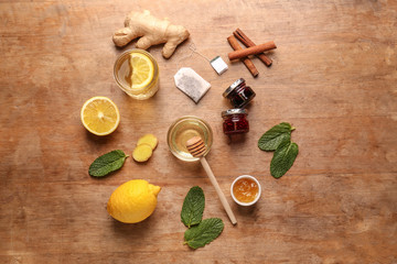 Fototapeta na wymiar Glass of tasty drink with lemon, honey and ginger on wooden table