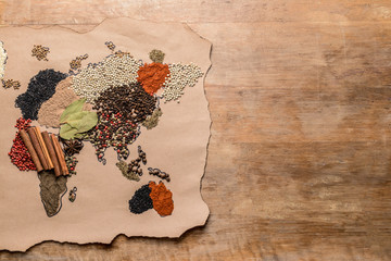 World map made of different spices on wooden background