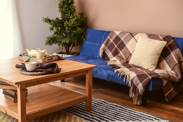 Fototapeta na wymiar Interior of living room with stylish blue sofa and wooden table