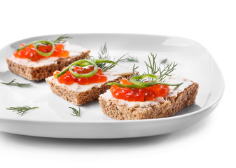 Plate with tasty canapes on white background