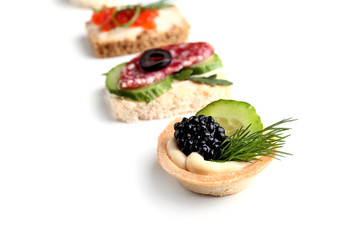 Assortment of tasty canapes on white background