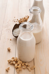 Assortment of tasty vegan milk on wooden table