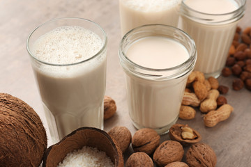 Assortment of tasty vegan milk on grey table