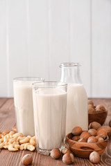 Assortment of tasty vegan milk on wooden table