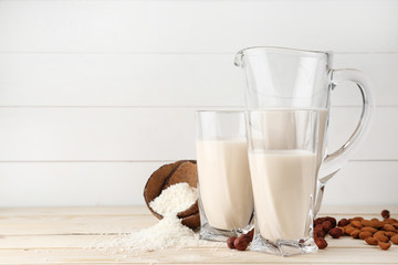 Assortment of tasty vegan milk on wooden table