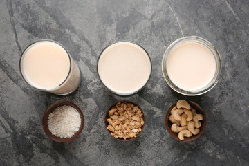 Assortment of tasty vegan milk on grey table