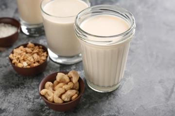 Assortment of tasty vegan milk on grey table
