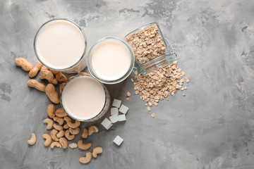 Obraz na płótnie Canvas Assortment of tasty vegan milk on grey background