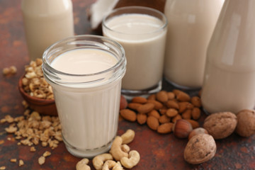 Assortment of tasty vegan milk on color background
