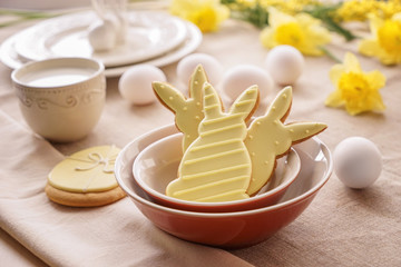 Bowls with tasty Easter cookies on table