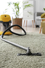 Vacuum cleaner on soft carpet in room