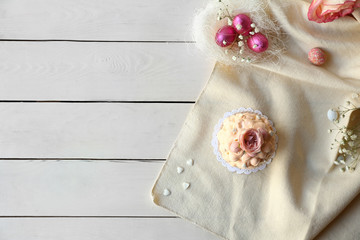 Tasty Easter cupcake with candies on white wooden background