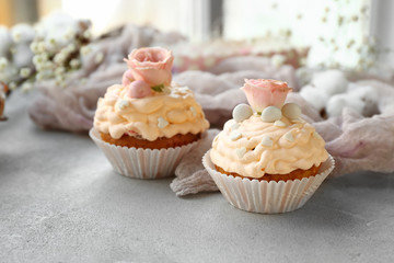 Tasty Easter cupcakes on grey table