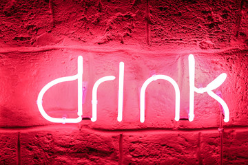 Neon sign on stone wall in darkness